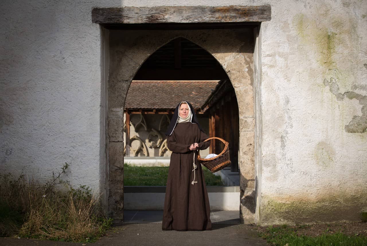Eine Klosterfrau steht in einem Tor