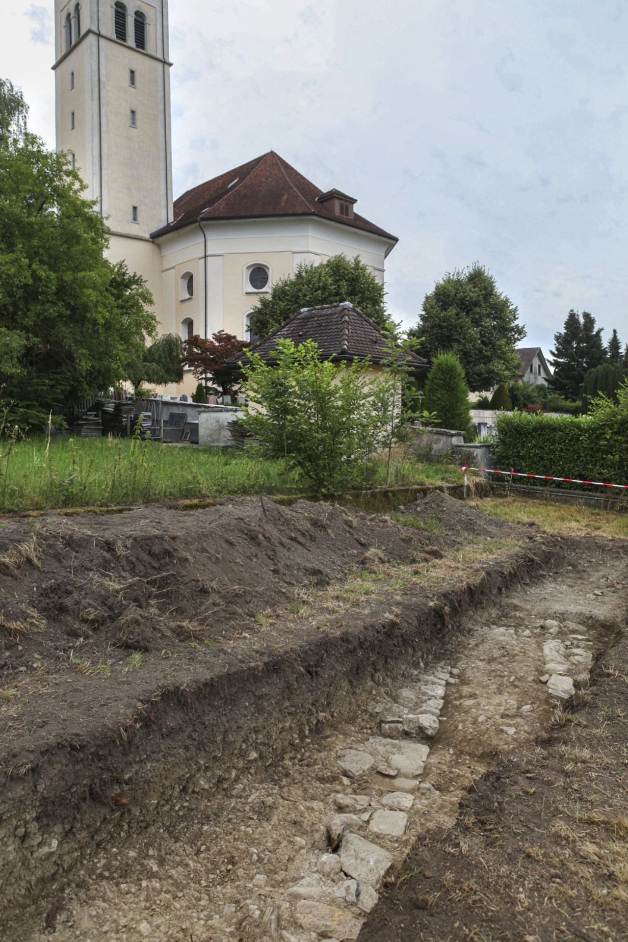 Die freigelegte römische Mauer. Im Hintergrund die Kirche von Seengen.