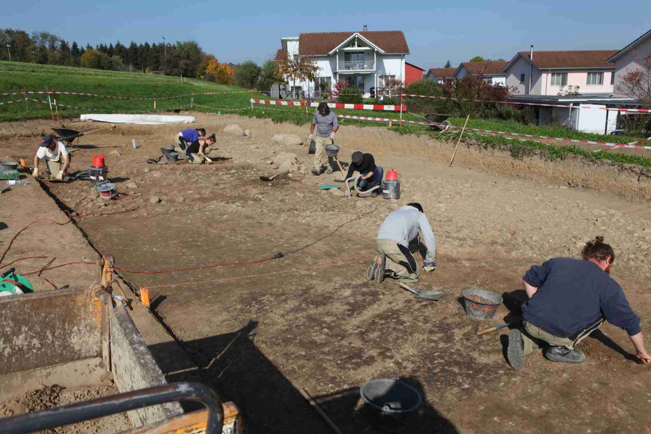 Ausgräberinnen und Ausgräber legen die archäologischen Schichten frei.