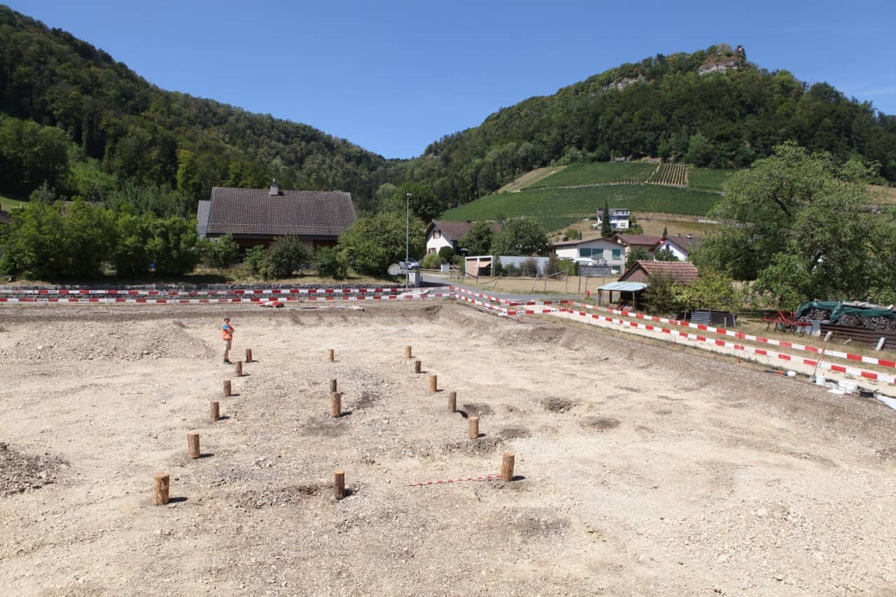 Die tragenden Pfosten des bronzezeitlichen Bauernhauses in Villigen-Obsteinen wurden für das Foto mit Stamm-Abschnitten markiert.