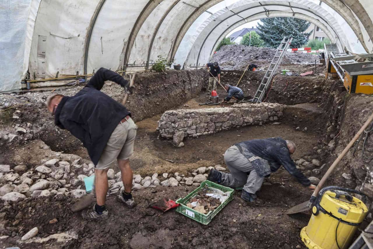 Ein Ausgrabungsteam legt zusammen römische Überreste frei.