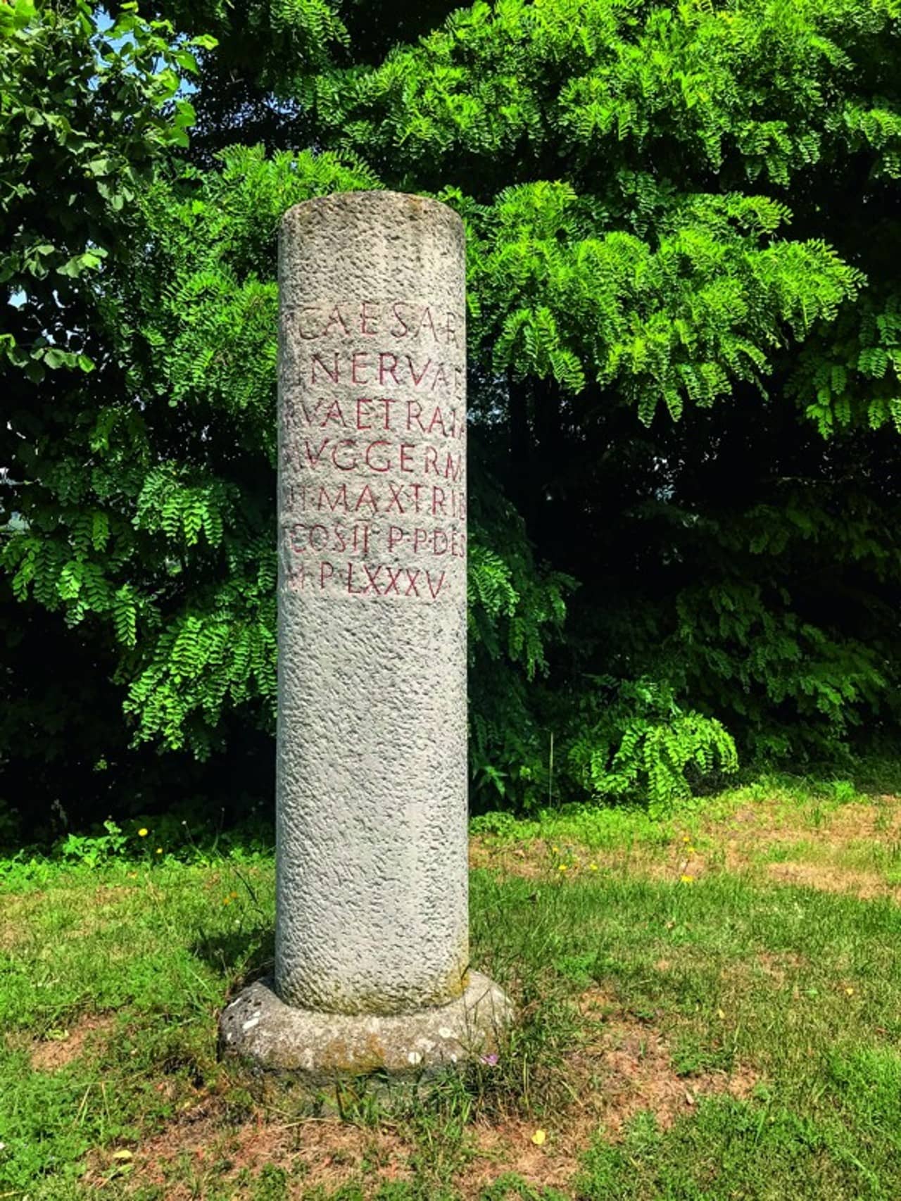 Replik eines römischen Meilensteins mit roter Schrift.