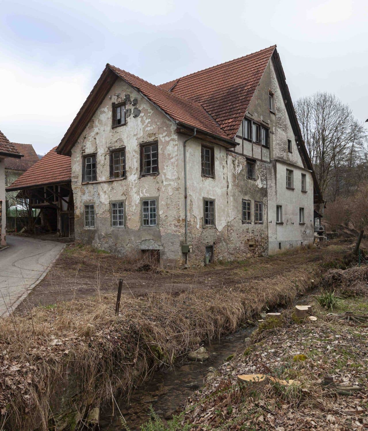 Weisses dreistöckiges Haus mit Ziegeldach.