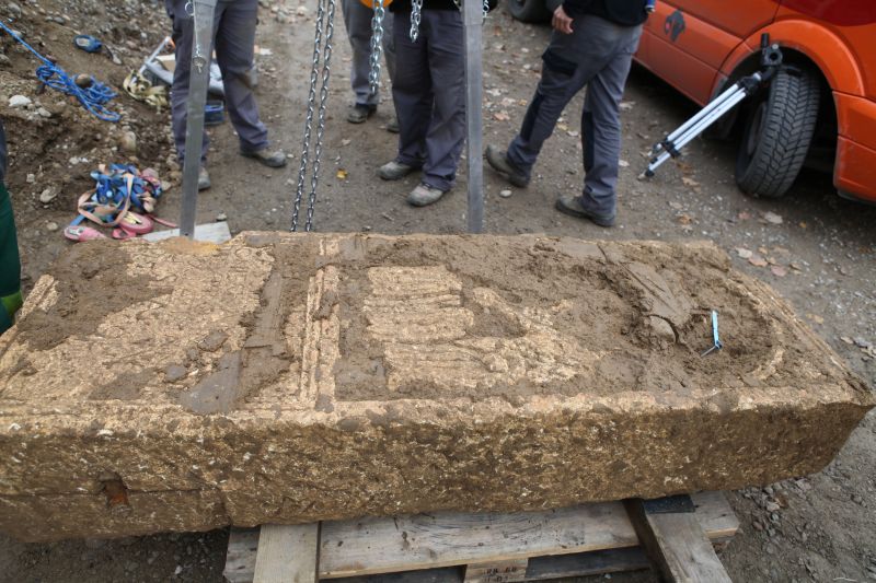 Der Grabstein direkt nach der Bergung. Man kann bereits eine Inschrift erahnen. 