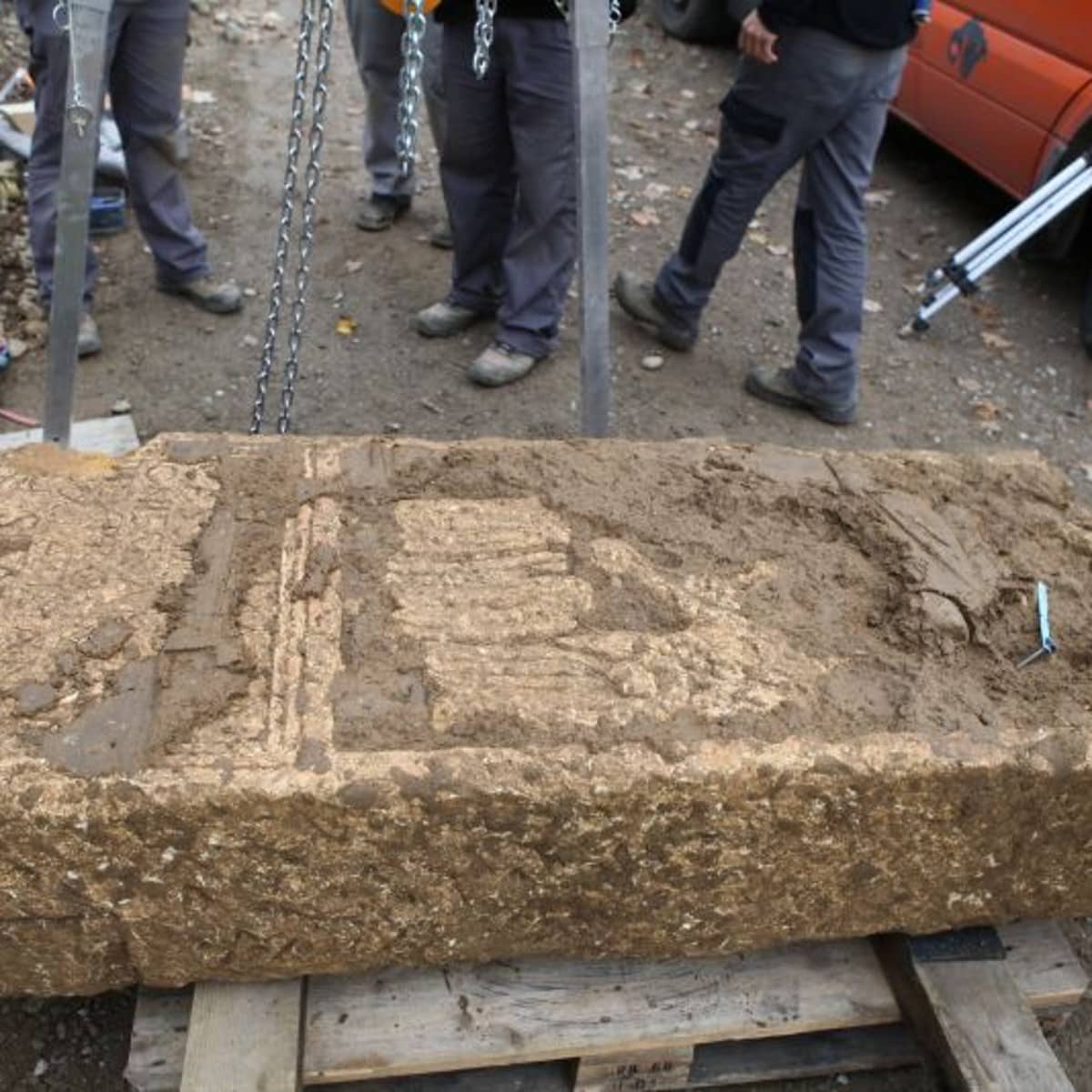 Der Grabstein direkt nach der Bergung. Man kann bereits eine Inschrift erahnen. 