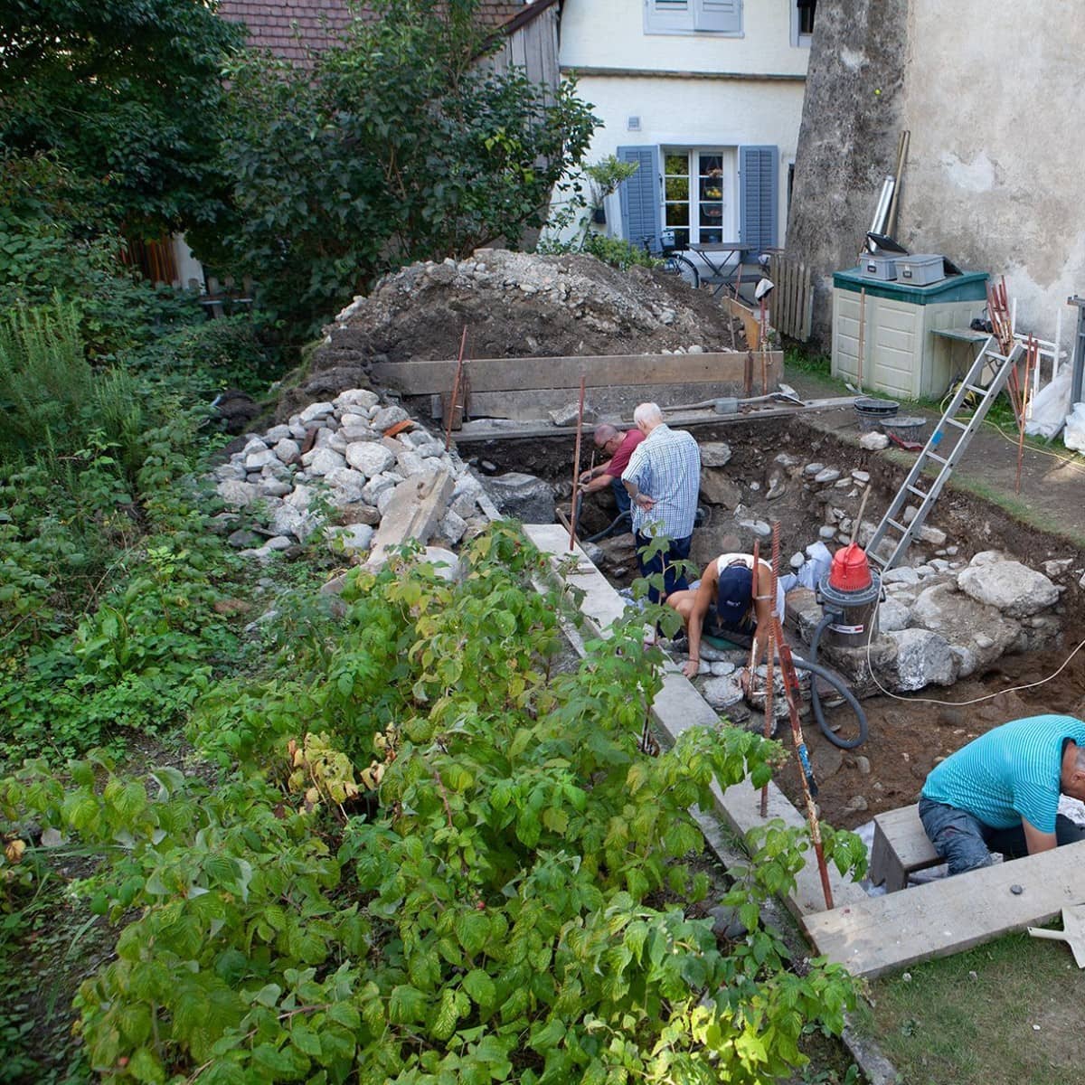 Freiwillige bei der Feldarbeit inmitten eines Gartens.