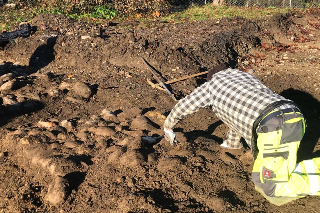 Ausgräber präpariert das Fundament der Kirche frei.