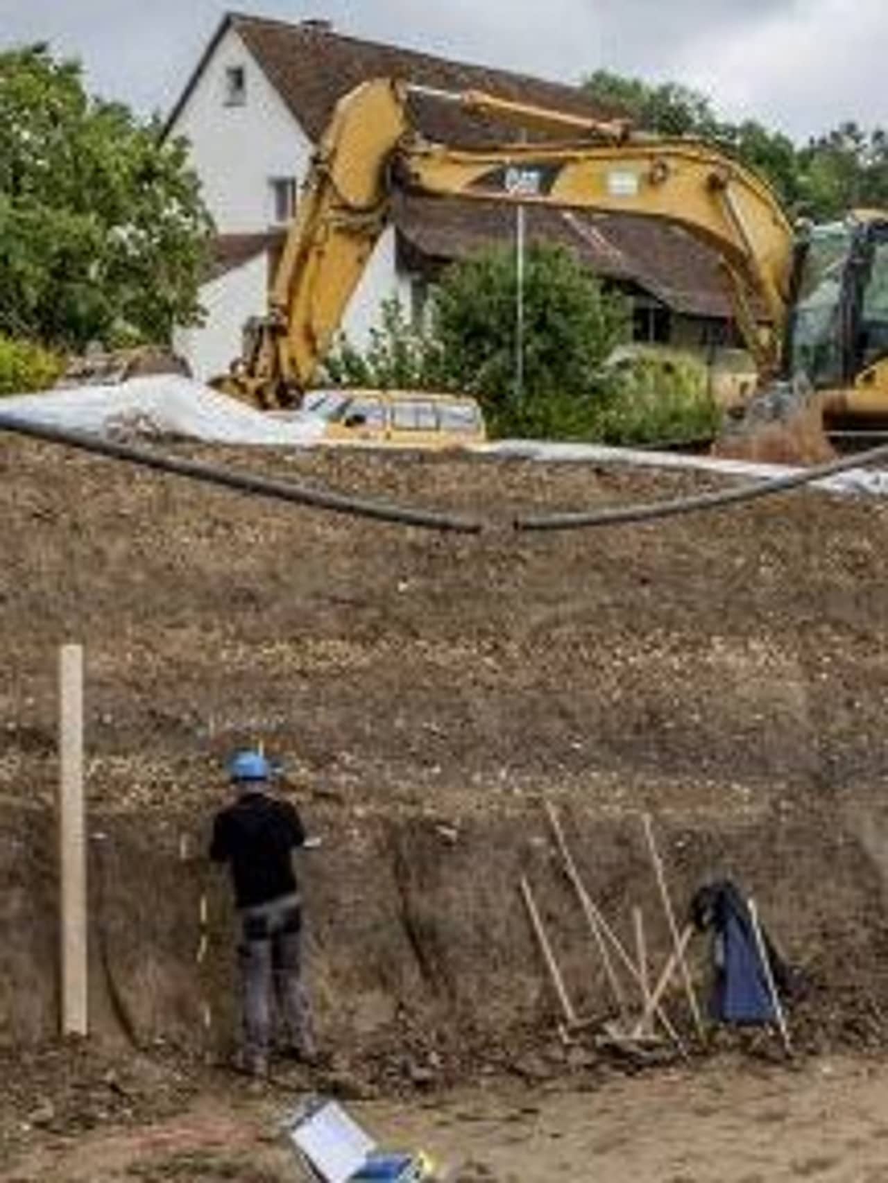 Ausgräber dokumentieren das über 4 Meter hohe Erdprofil.