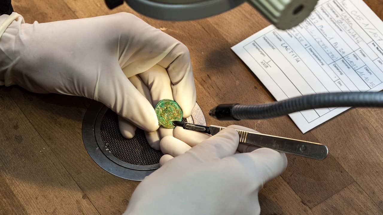 Fachleute restaurieren die Münzen des Schatzes.