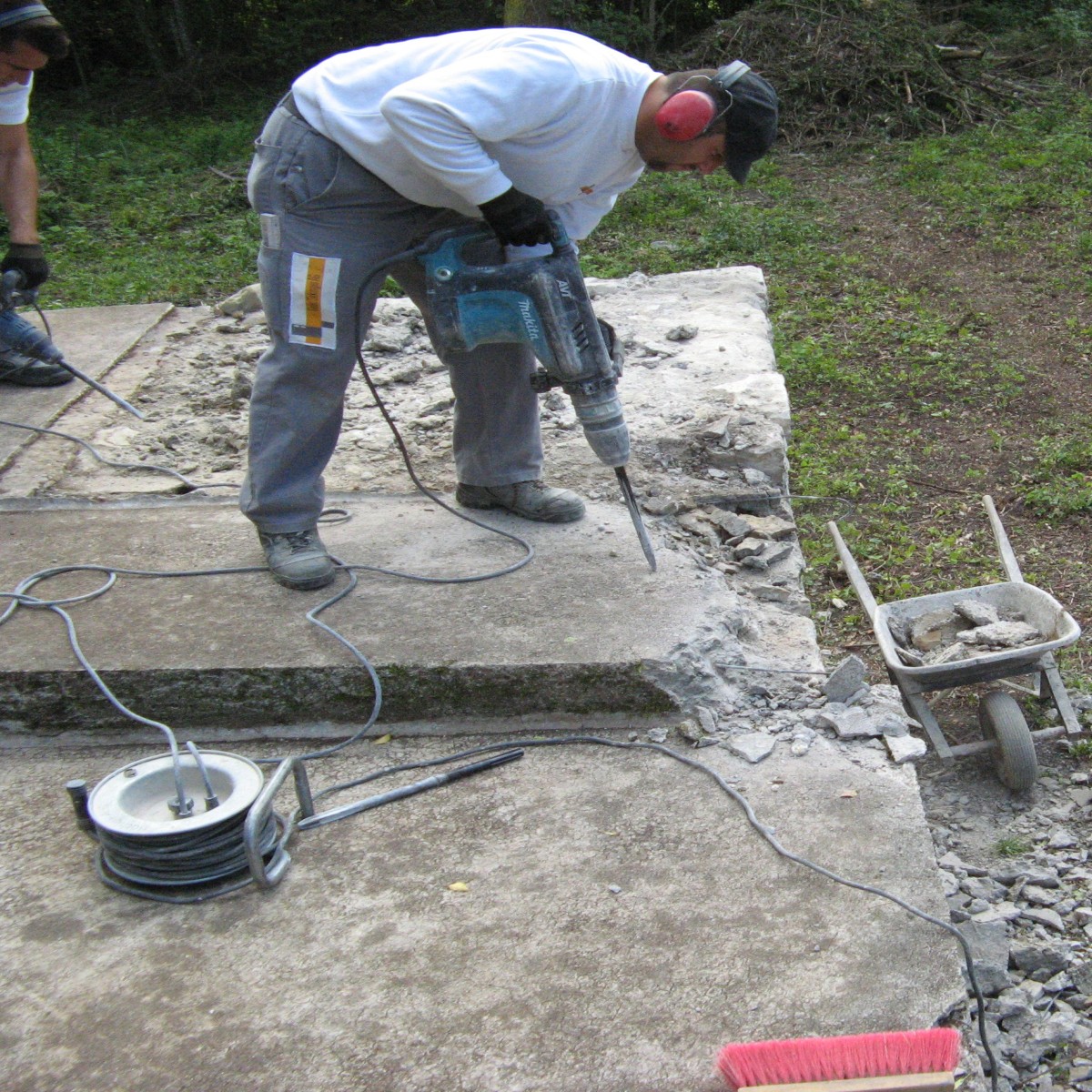 Man bearbeitet römische Mauer mit Presslufthammer.