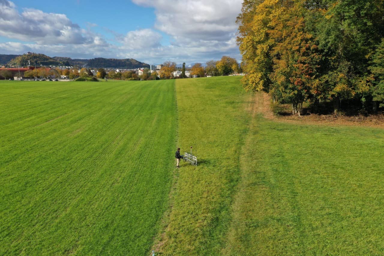 Ein Archäologe untersucht mittels Geomagnetik zerstörungsfrei ein Feld.