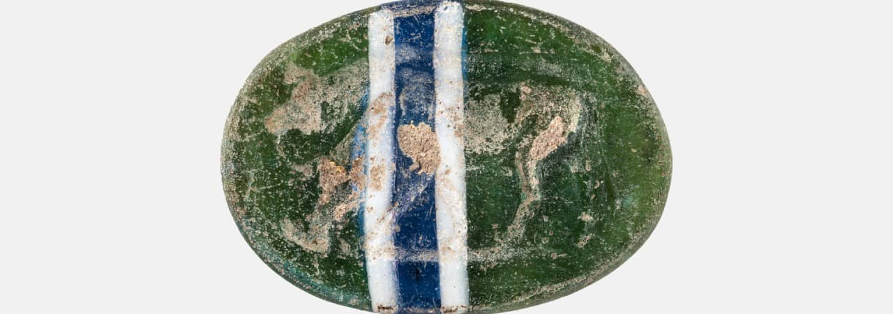 Grüne Glasgemme mit blau-weissem Streifen.