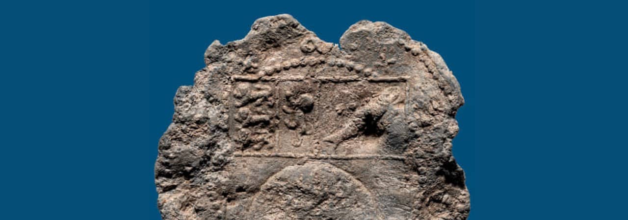 Runde hellgraue Scheibe aus Blei mit eingeprägtem Wappen.
