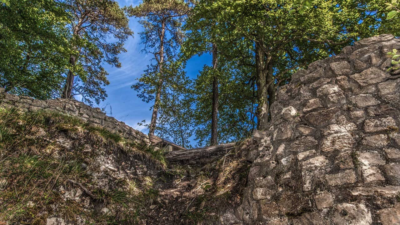 Blick von unten auf die Burg mit einer Aussichtsbank