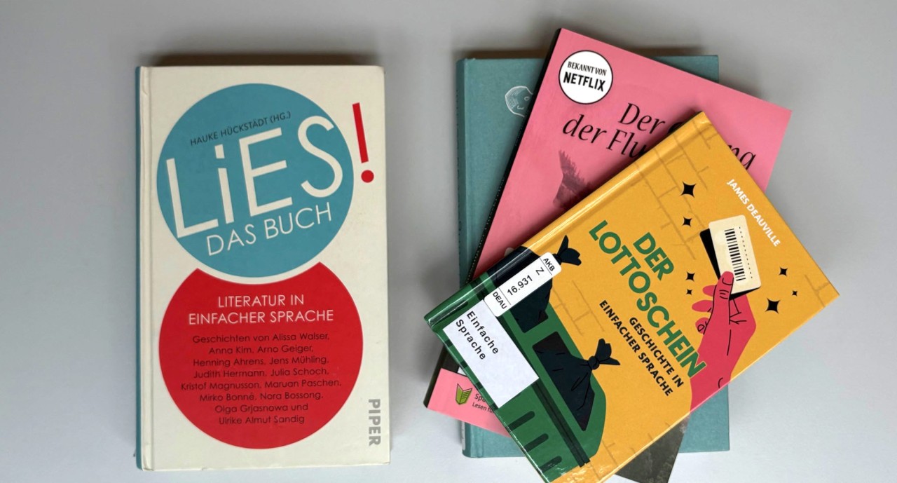 Links ein Buch mit dem Schriftzug Lies das Buch in einem blauen Kreis. Rechts daneben drei Bücher übereinander gestapelt.
