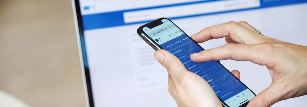 Foto von PC-Bildschirm und Smartphone, auf denen die Webssite der Kantonsbibliothek angezeigt wird.