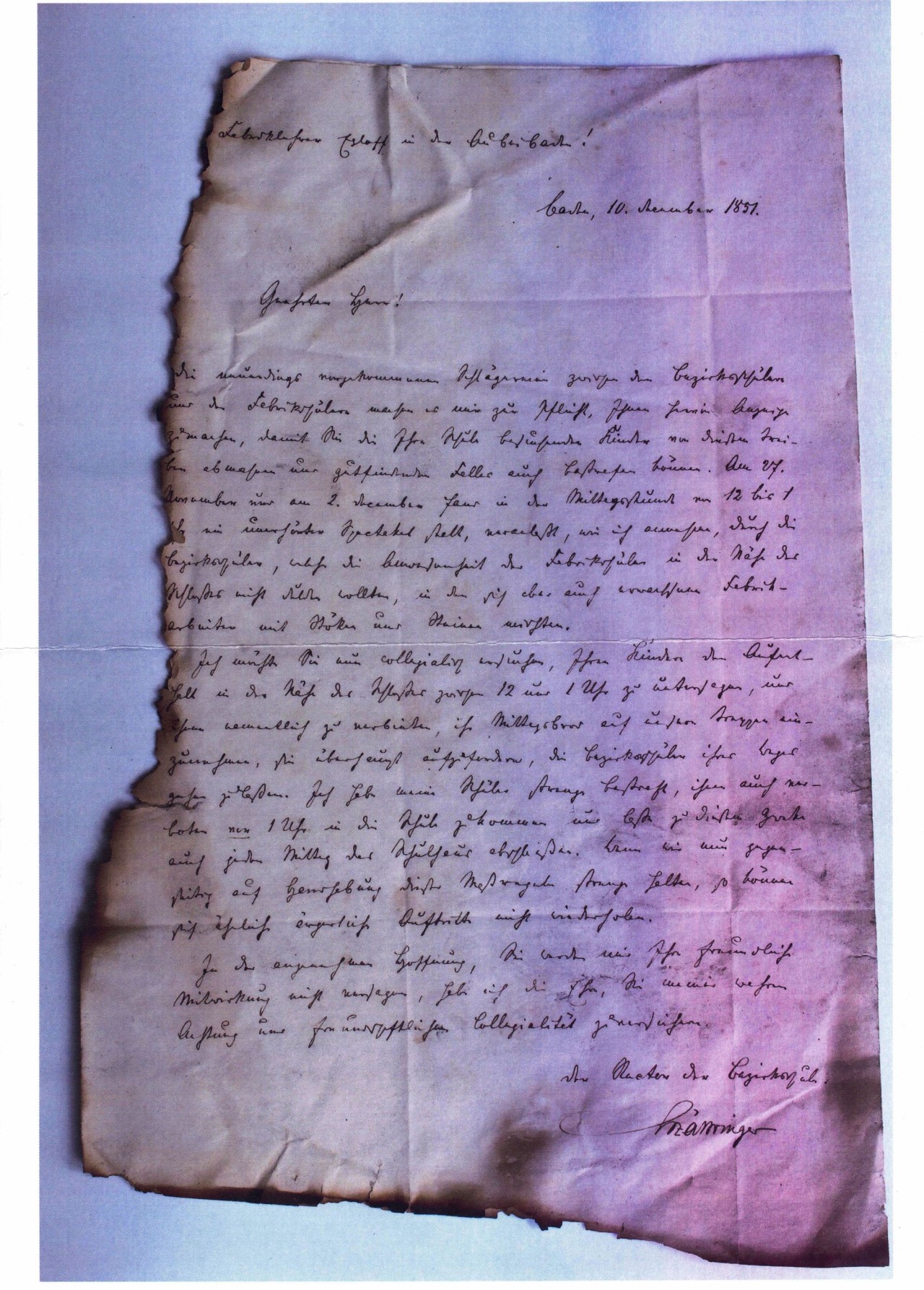 Handgeschriebener Brief in alter Schrift mit verbrannten Rändern.