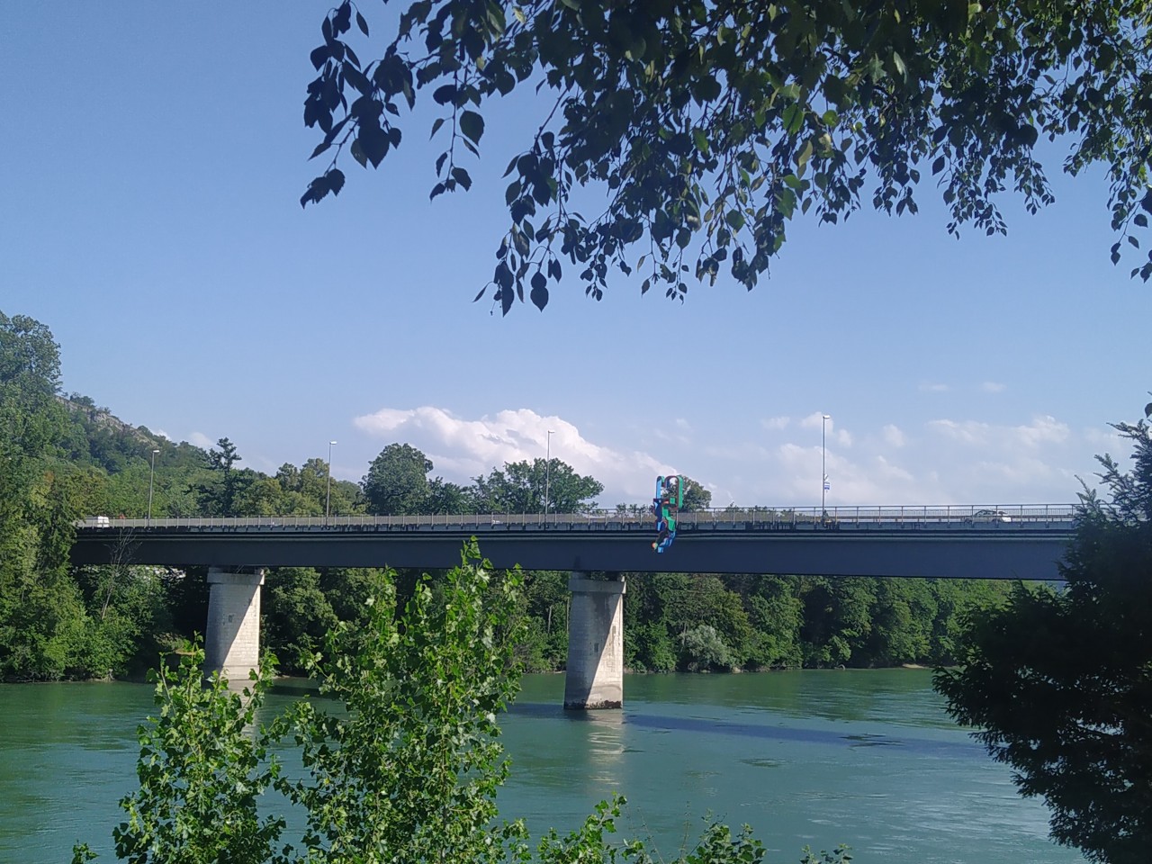 Farbfoto einer Autobrücke, die über einen Fluss führt.