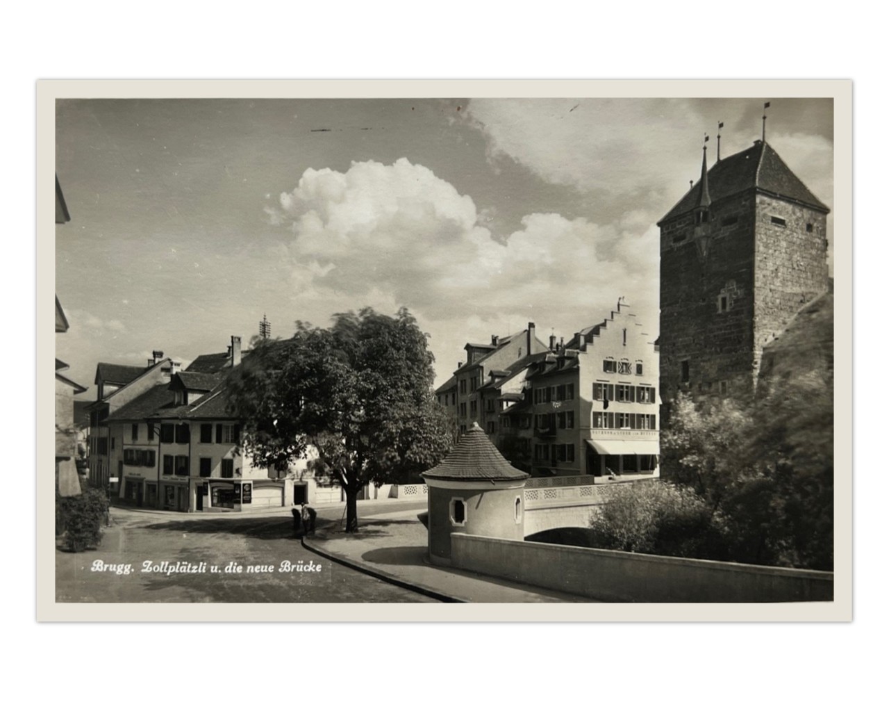 Eine alte Postkarte mit einem schwarz-weissen Foto, welches das Brugger Zollplätzli und die Aarebrücke mit dem schwarzen Turm zeigt.