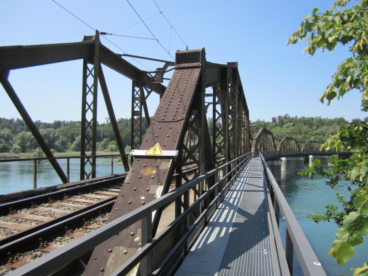 Farbfoto mit Blick durch eine Eisenbahnbrücke.