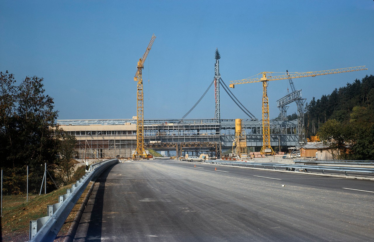 Baustelle mit drei Kränen auf einer Strasse. Gebaut wird eine Brückenkonstruktion.