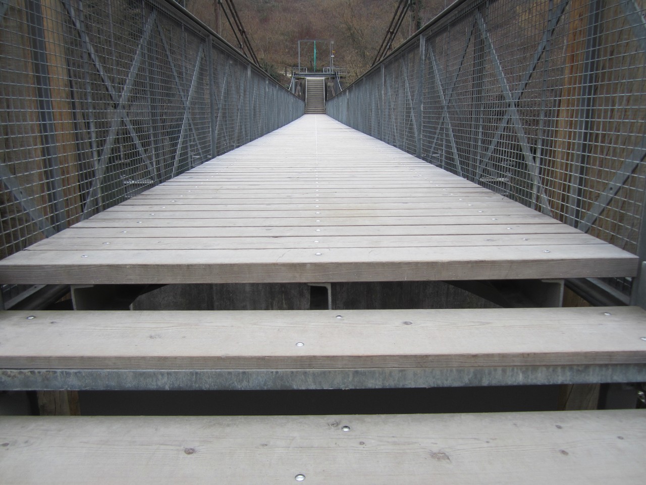 Blick über eine Brücke mit Holzboden. Froschperspektive.