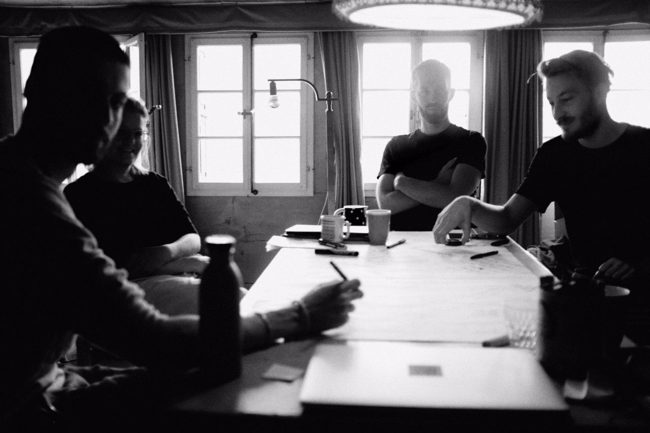 Schwarzweiss Foto einer Gruppe bei einer Sitzung.