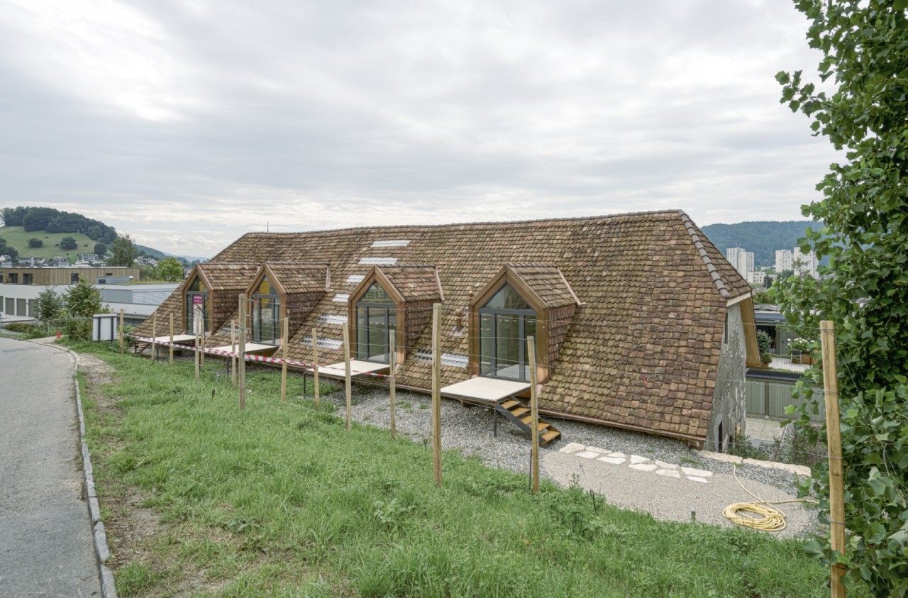 Trotte von Norden, nach dem Umbau, mit historischen Ziegeln eingekleidete Giebellukarnen erinnern an die ursprüngliche Zugangslukarne.