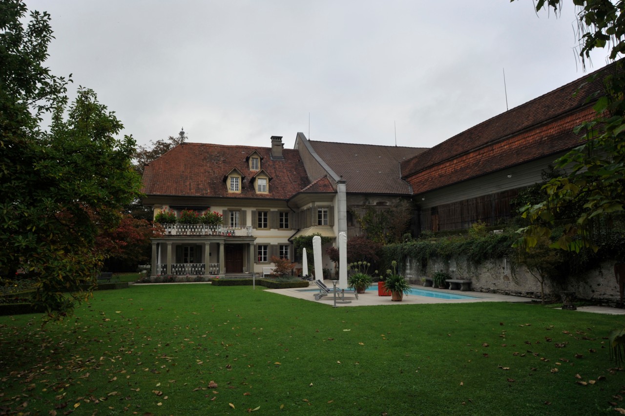 Das Herrenhaus mit angrenzender Scheune vor dem Brand.