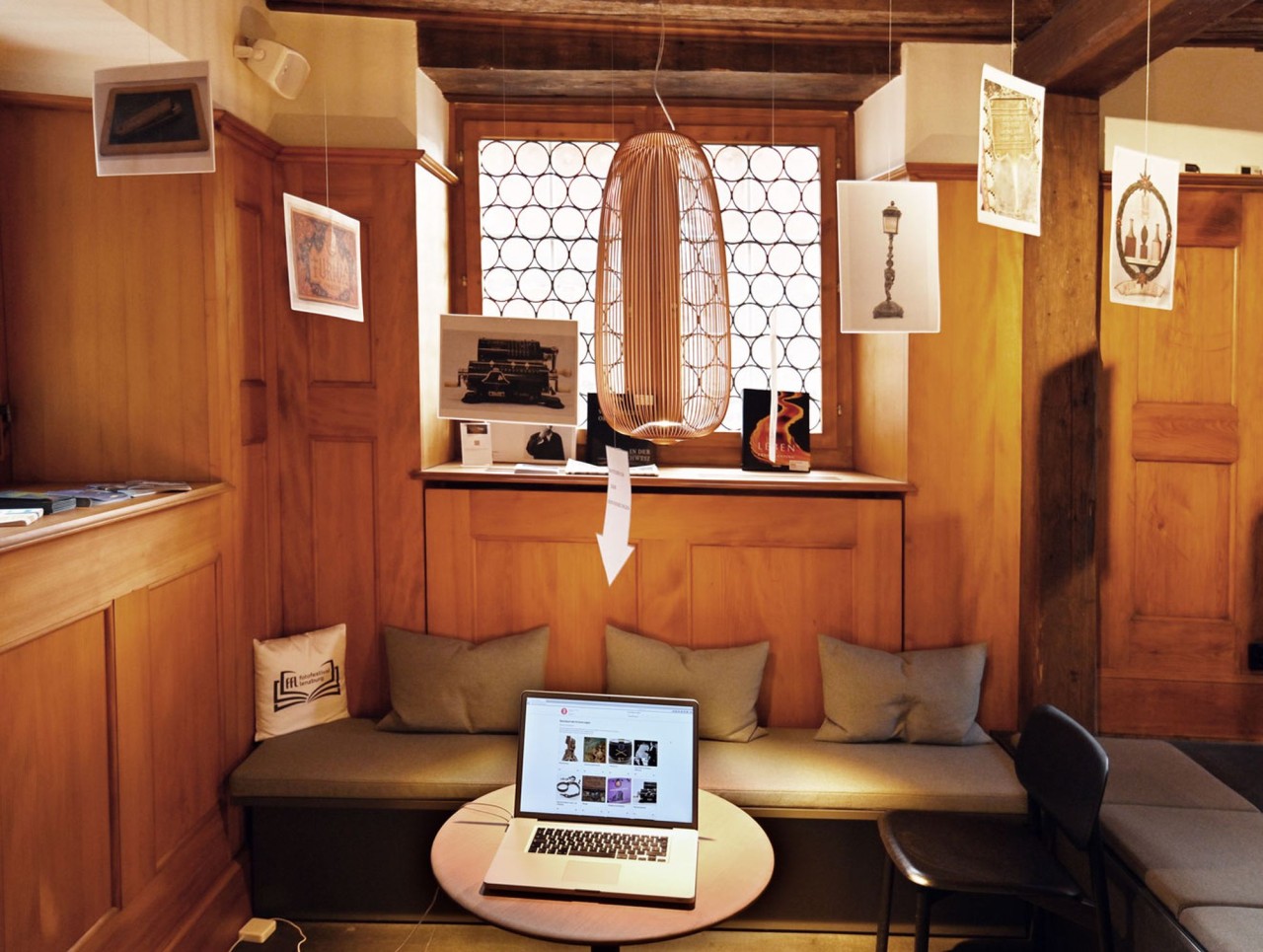 Ein in Holz eingekleideter Raum mit Sitzgelegenheiten und einem Laptop
