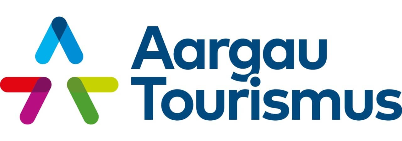 Logo im Querformat mit "Aargau Tourismus" als Schriftzug in dunkelblau. Links des Schriftzugs farbige Dreiecke, die ein "A" bilden.