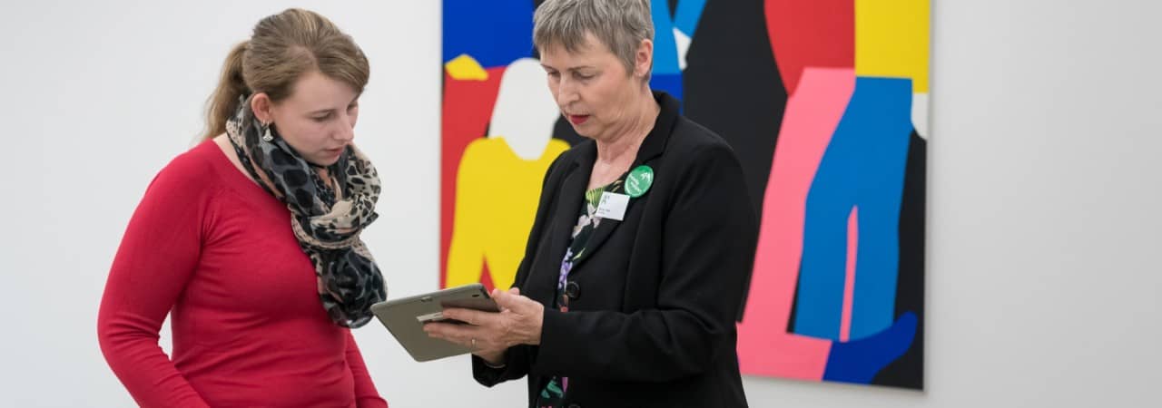 Freiwillige zeigt Sammlung online auf den Tablet.