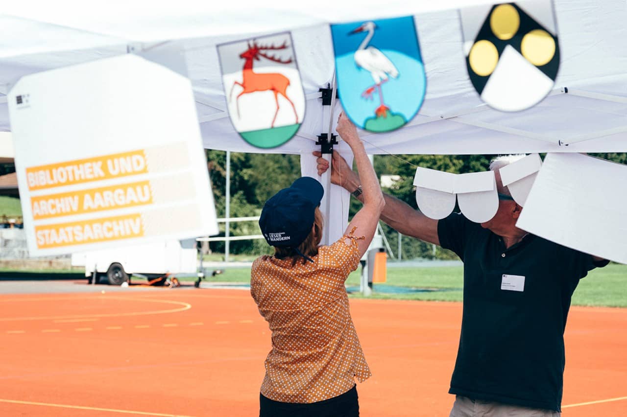 Freiwillige helfen ein Festzelt aufzubauen.