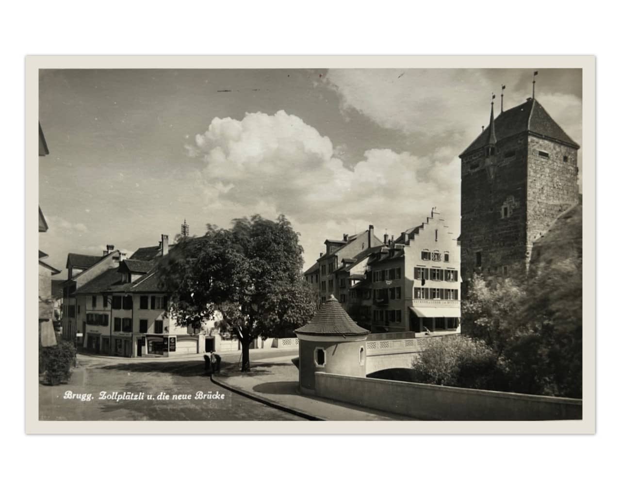 Eine alte Postkarte mit einem schwarz-weissen Foto, welches das Brugger Zollplätzli und die Aarebrücke mit dem schwarzen Turm zeigt.