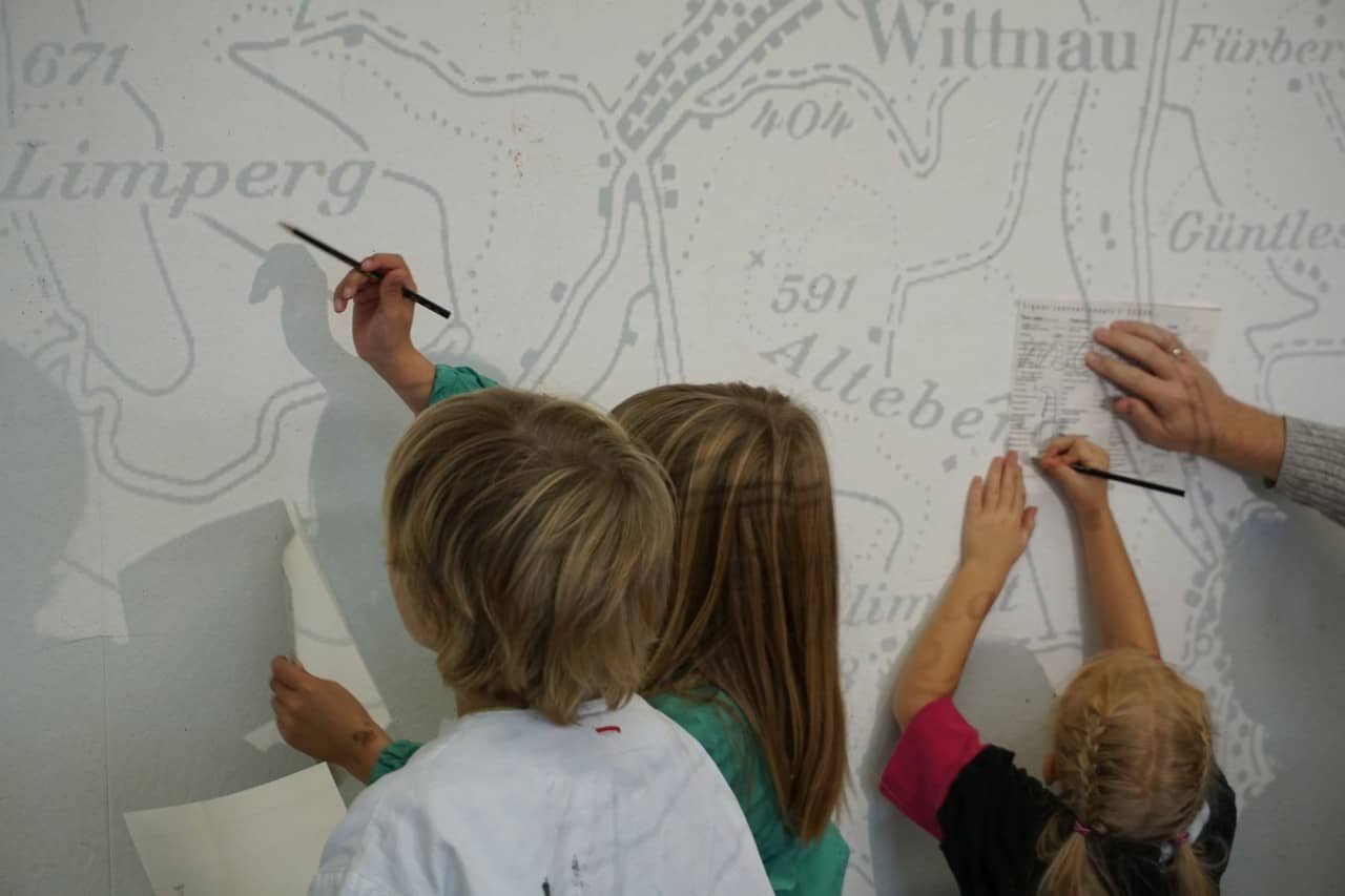 Kinder pausen eine grosse Karte an der Wand ab