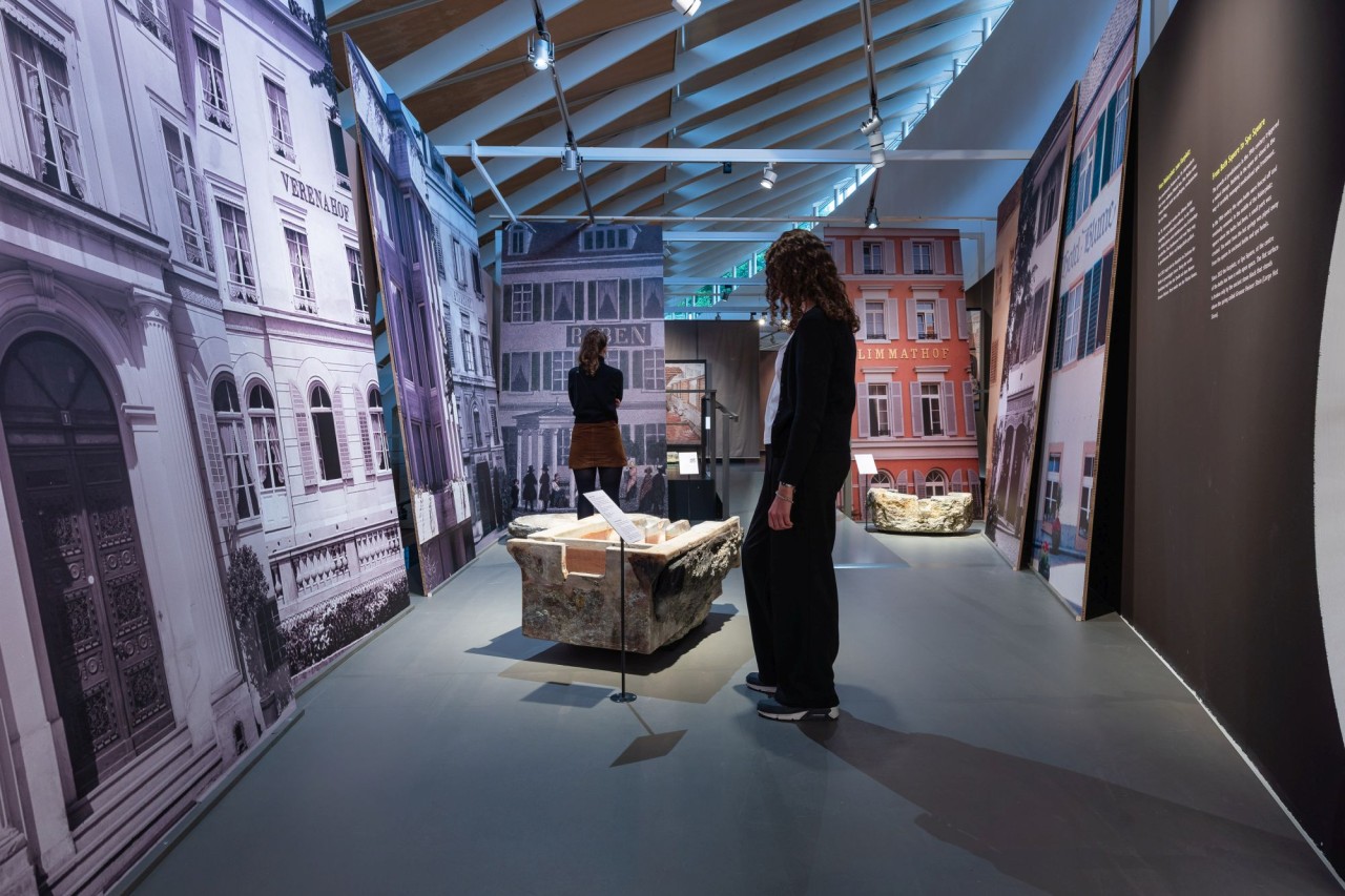 Zwei Personen befinden sich in einem Ausstellungsraum zum Thema Bäderstadt Baden.