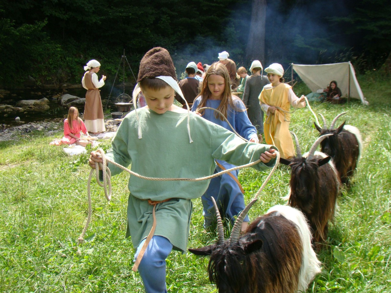 Schülerinnen und Schüler sind als mittelalterliche Hirten kostümiert und führen Ziegen.