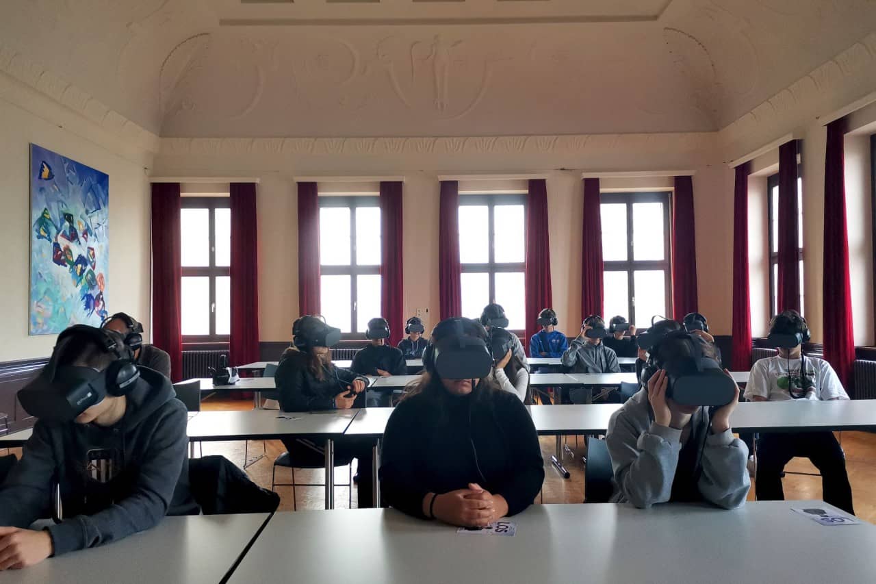 Schülerinnen und Schüler tragen VR-Brillen