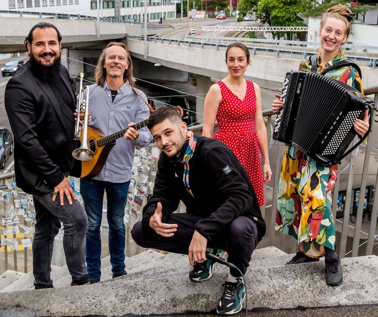 Fünf Musikerinnen und Musiker halten unterschiedliche Instrumente in der Hand.