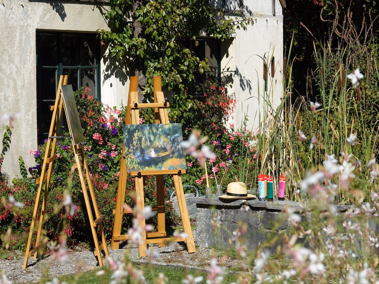 Bild einer Staffelei in einem blühenden Garten.