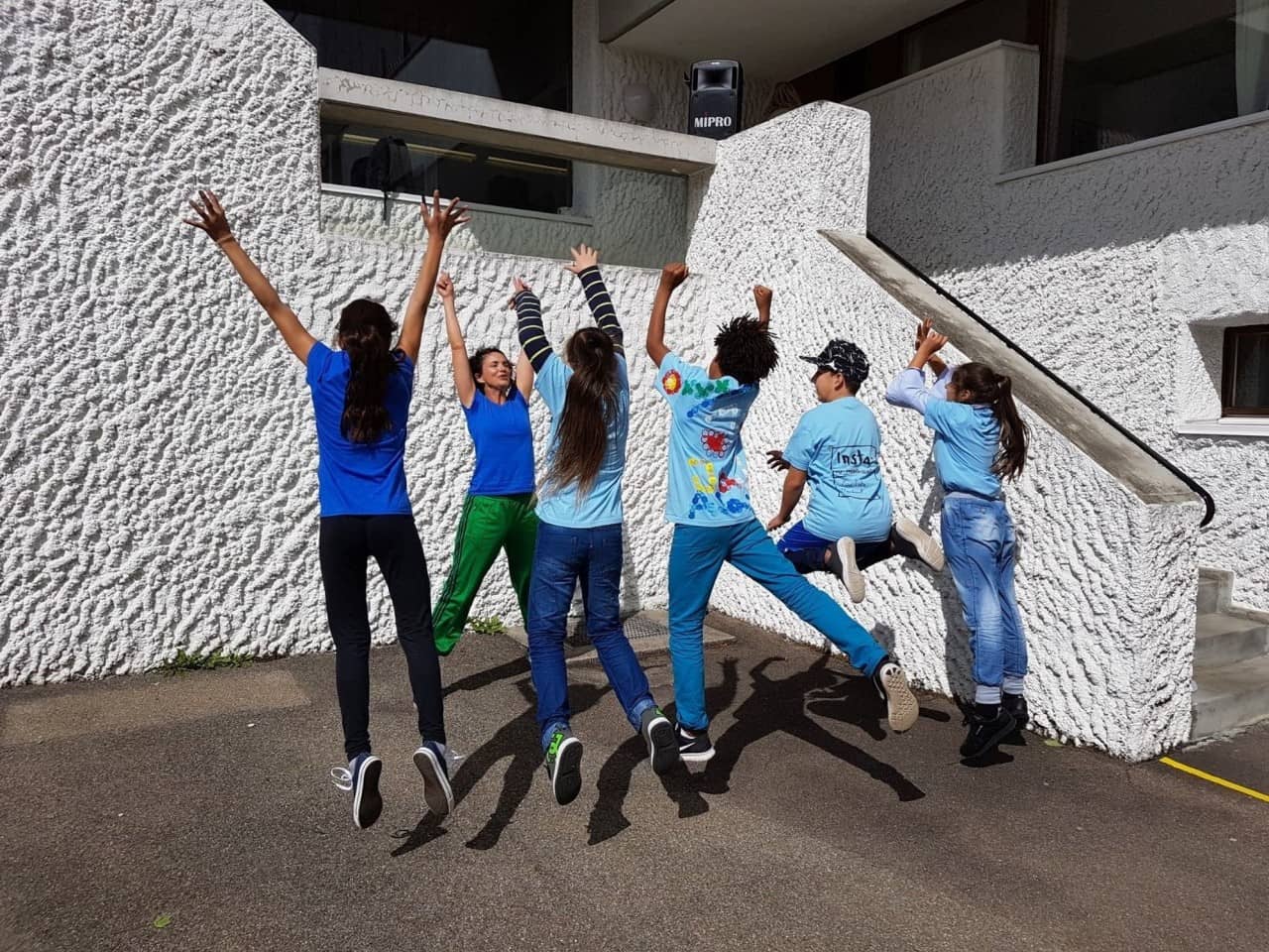 Schülerinnen und Schüler springen in die Luft.
