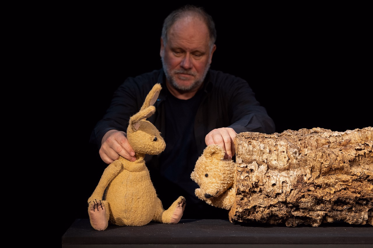 Ein Figurenspieler hält einen Hasen und einen Bären in der Hand.