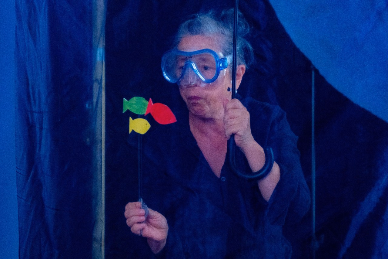 Eine Frau trägt eine Tauchermaske und betrachtet Fische.