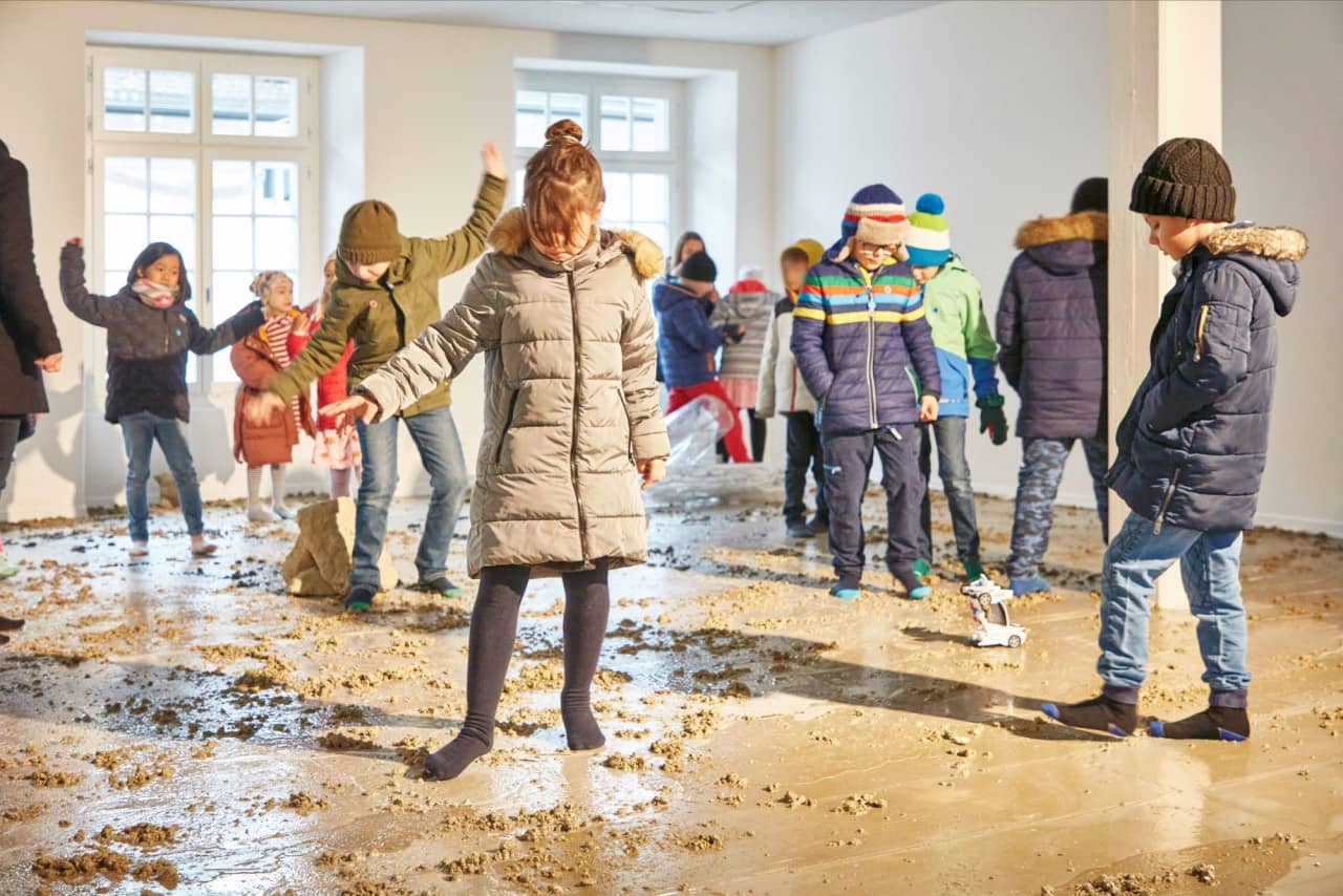 Schülerinnen und Schüler ertasten den schlammigen Boden mit ihren Füssen.