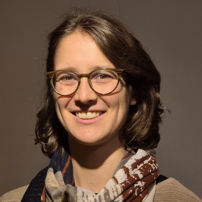 Person mit Brille lächelt in Kamera.