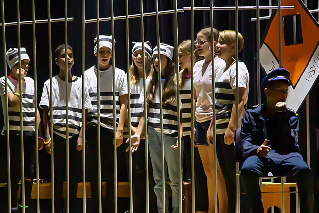 Schülerinnen und Schüler verkleidet als Inhaftierte hinter Gittern