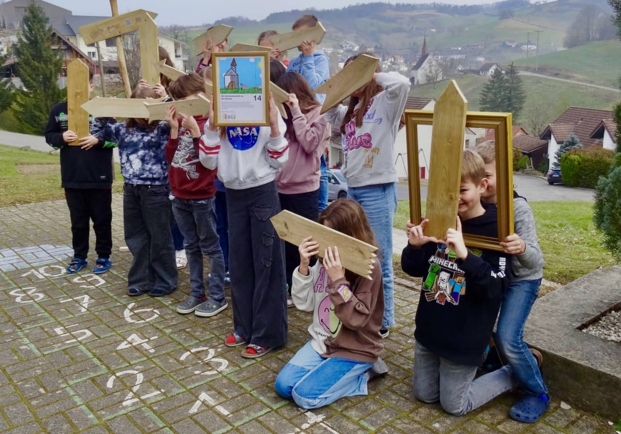 Eine Schulklasse mit Wegweisern aus Holz vor dem Gesicht