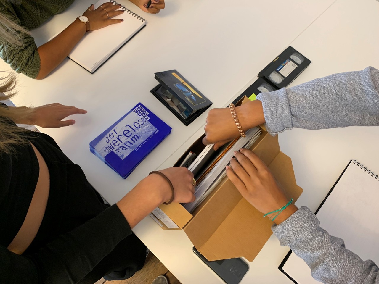 Materialien werden in eine schmale Kartonbox gepackt.
