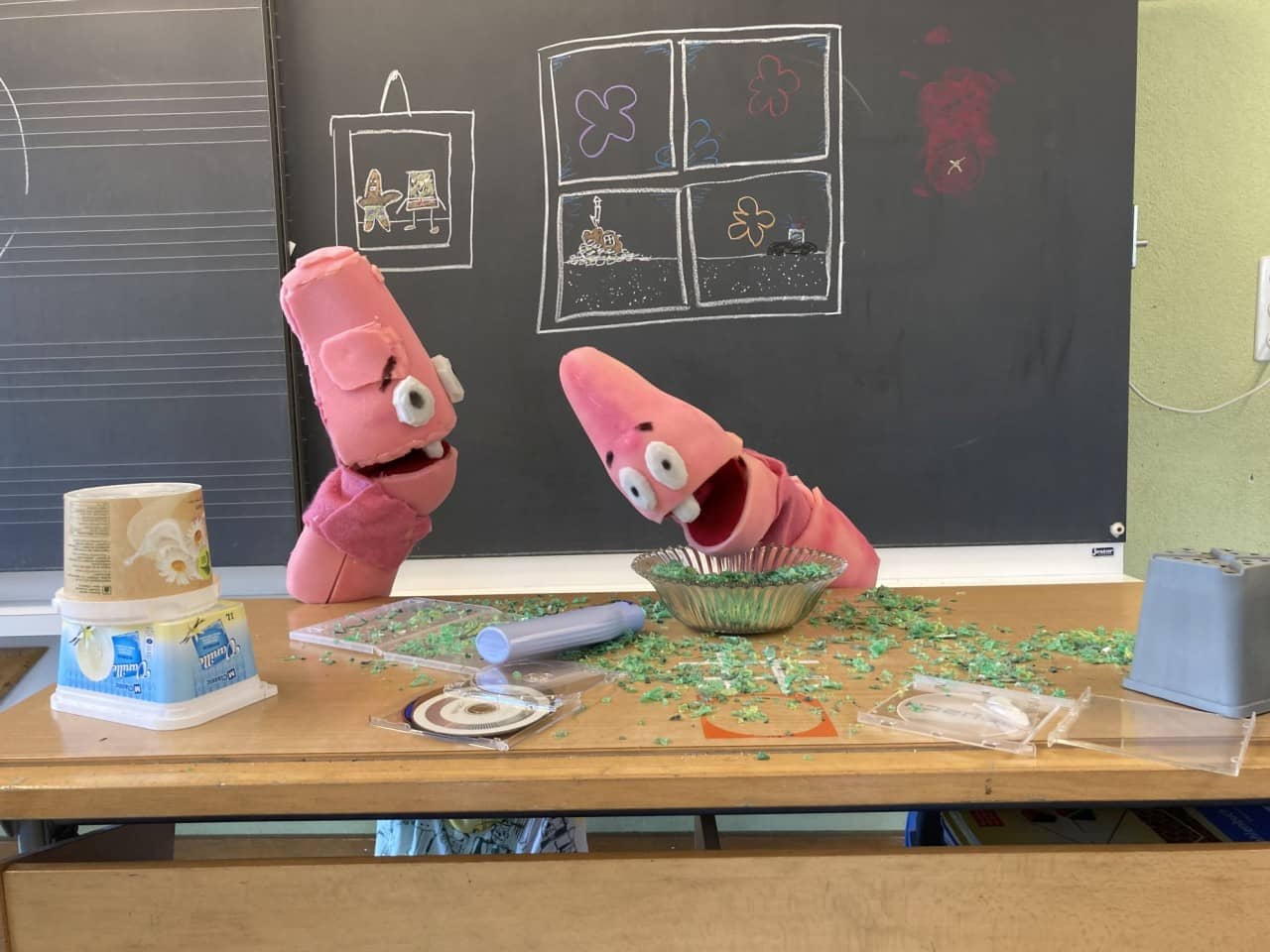 Zwei pinke Puppen an einem chaotischen Schreibtisch