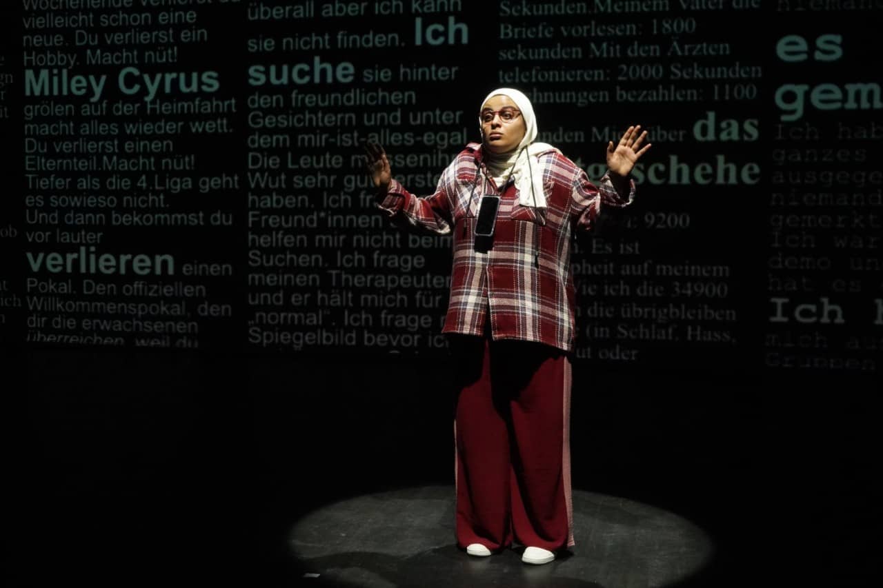 Jugendliche mit Smartphone vor einer Text-Projektion an der Wand